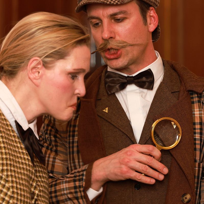 Conan Doyle mit Lupe erklärt Eliza etwas