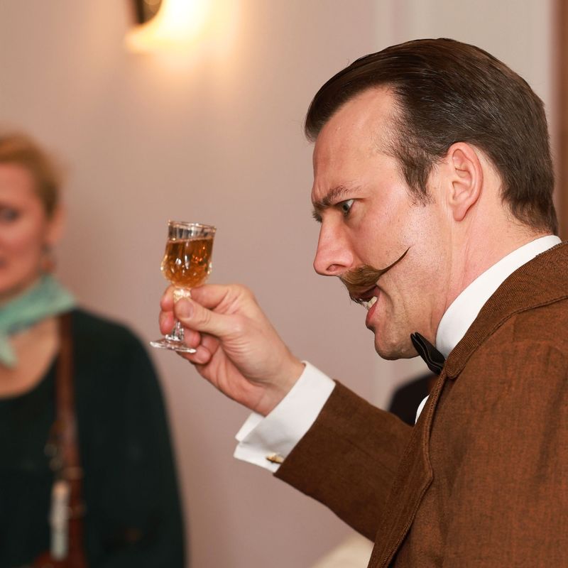 Conan Doyle mit Sherryglas, Erfinderin schaut zu