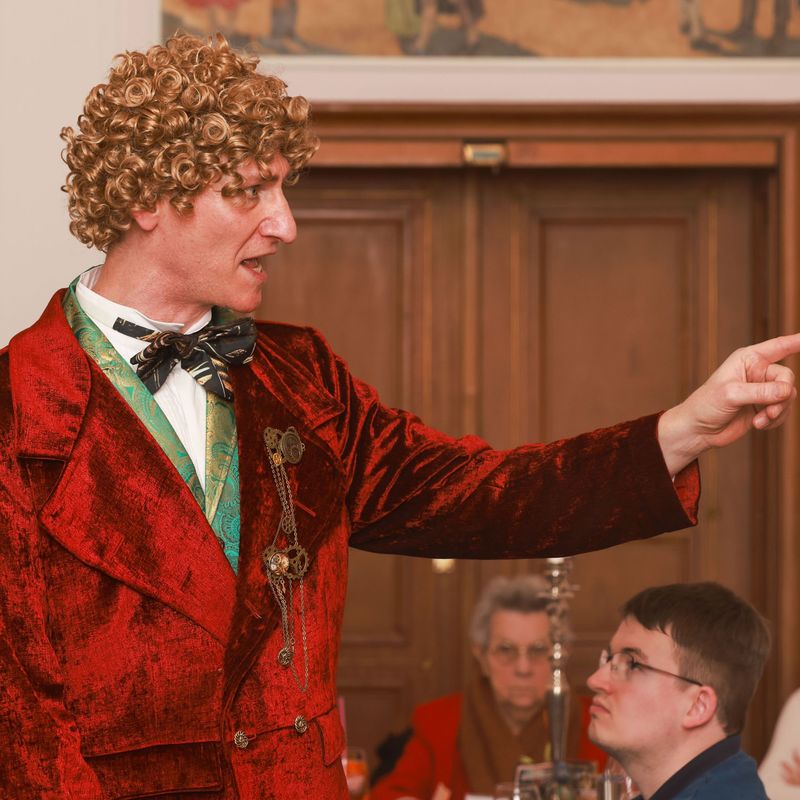 Sir John mit ausgestrecktem Arm am Erklären